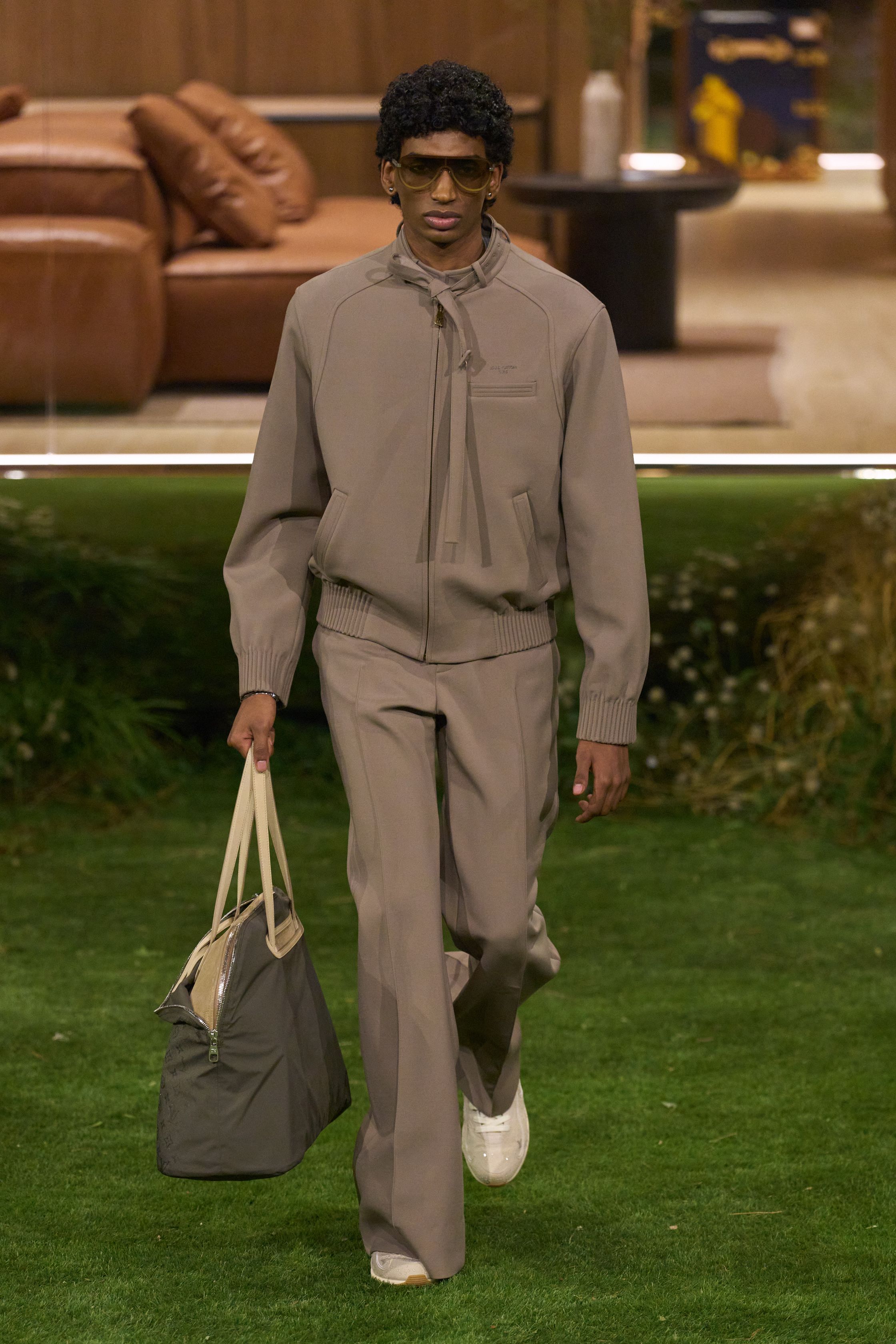 Louis Vuitton 26FW 男装以“当代绅士的旅行状态”为核心，在花园式场景中展开一场关于移动、身份与功能的叙事。功能夹克、细致西装、学院感针织与标志性包袋并行出现，色彩回归卡其、橄榄绿、灰褐与深红，呈现出低调却高度可穿的奢华现实主义。系列强化了“穿着中的生活感”，将品牌传统的旅行基因转译为更克制、更日常的现代衣橱方案-顽石频道趋势研究